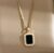 Gold-tone necklace features a rectangular black stone pendant